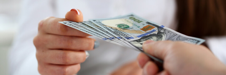 Male arm pay bunch of hundred dollars bills