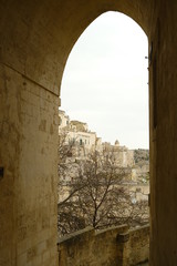 Road in the ancient city of Matera. Paving with beige stone and covering with arch and vault.
