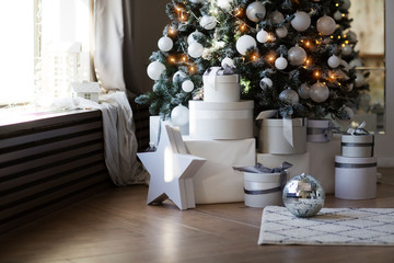Interior living room with a Christmas tree and decorations. Stack presents under Christmas tree