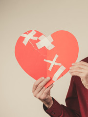adult man holding broken heart