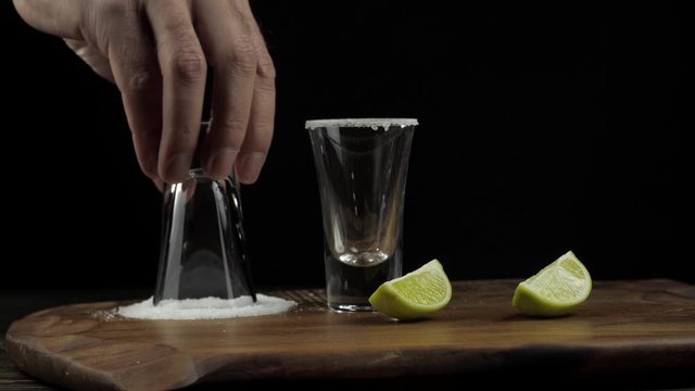 the bartender prepares tequila and dabs a stick in the salt, next to the lime