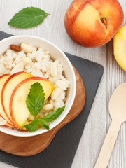 Sorghum salad with nuts and fresh peach on stone board.