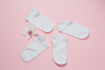 Two pairs of women socks on pink background.