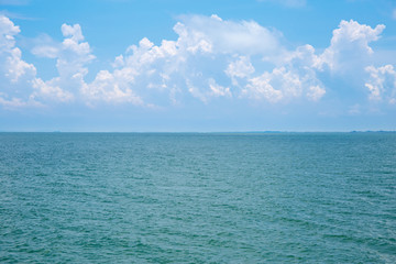 Clean blue sea water or ocean and clear blue sky and white clouds.