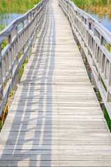 Walkway or walk path wooden bridge in lake swamp or river.