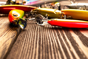 Fishing tackle background. Fishing tackles and wobbler on wooden board. Fishing hooks, lures and...