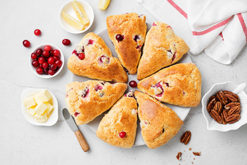 Scones with fresh cranberry and pecan nuts on gray stone background. Top view