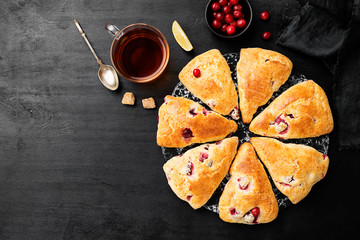 Scones with fresh cranberry  on black wooden background. Top view
