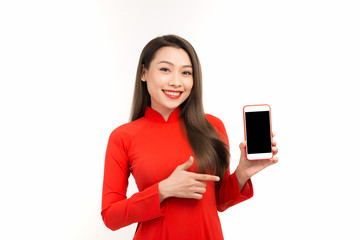 Beautiful young Vietnamese woman in red showing blank display of a smartphone isolated over white