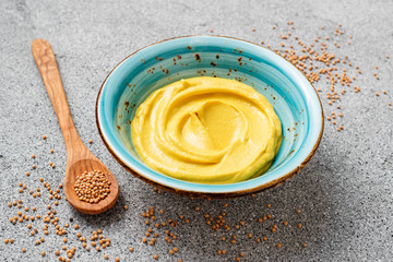 Delicious  organic  mustard sauce in bowl with wooden spoon.