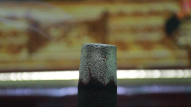 Close up shot of dhoop batti / incense stick burning with some smoke on the pooja room
