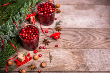 Christmas drinks. Hot winter drink with cranberries and cinnamon on a wooden table. Top view flat lay. Free space for your text. 