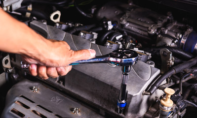 Fototapeta na wymiar Hand of auto mechanic technician service engine and using wrench socket