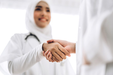 Success of handshake two muslim asian female doctor in hospital.healthcare and medicine