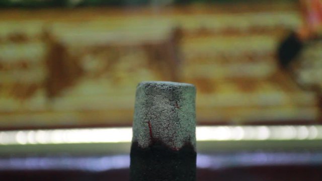 Close up shot of dhoop batti / incense stick burning with some smoke on the pooja room