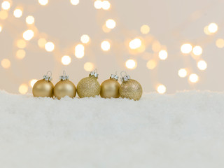 many different christmas items on white snow with many small, shining lights in the background