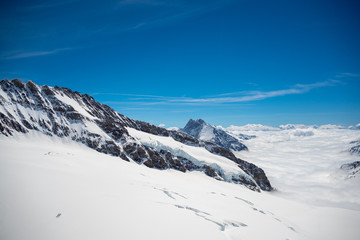 Fototapeta na wymiar Beautiful scene of snow mountain above cloud with clear blue sky, Jungfrau, Switzerland, for background, copy space