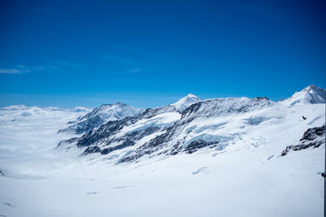 Fototapeta na wymiar Beautiful view of snow mountain above cloud with clear blue sky looking from viewpoint, Jungfrau, Switzerland, for background, copy space