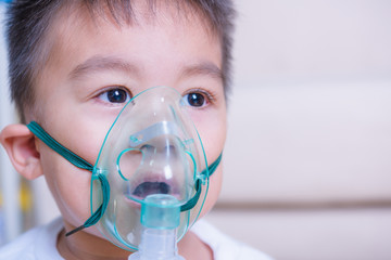 Closeup asian face little children boy using steam inhaler nebulizer mask inhalation