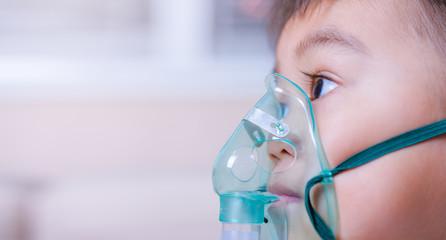 Closeup asian face little children boy using steam inhaler nebulizer mask inhalation