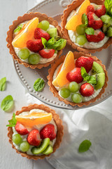 Top view of mini tart with fruits and cream