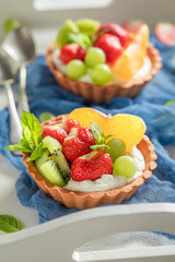 Homemade mini tart made of whipped cream and fresh fruits
