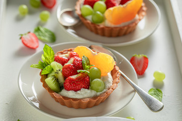 Homemade mini tart with strawberries, orange, kiwi and grapes