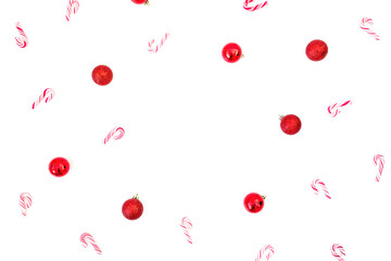 Christmas frame with red decoration and candy cane on white background. Flat lay