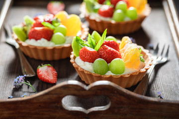 Tasty mini tart with strawberries, orange, kiwi and grapes