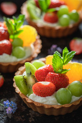 Delicious mini tart with strawberries, orange, kiwi and grapes