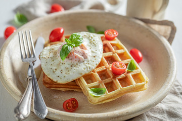 Fresh waffles with fried eggs and cherry tomatoes