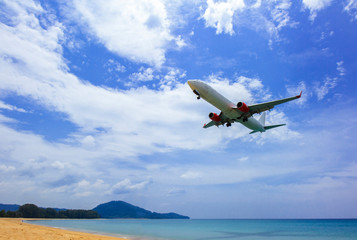 Fototapeta na wymiar Airplane in the sky with sea and beach