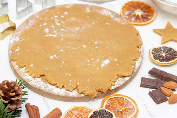Christmas food. copyspace. Homemade gingerbread cookies with ingredients for Christmas baking and kitchen utensils on a white table, top view. flour, dough, rolling pin, cinnamon