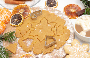 Christmas food. Homemade gingerbread cookies with ingredients for Christmas baking and kitchen utensils on a white table, top view. flour, dough, rolling pin, cinnamon, ginger, chocolate, gingerbread