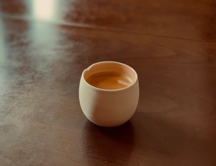 coffee in a white cup on a wooden table