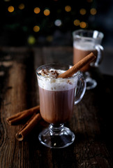 Cup of hot chocolate with cinnamon decoration on wooden table background