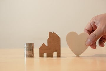 Property investment and house mortgage financial concept, Hand putting money coin stack with wooden...