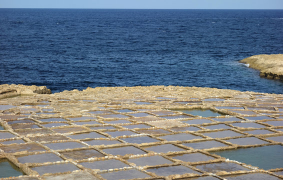 Salt pans in Xwejni, Zebbug, Gozo, Malta, longtime locale for salt production, featuring salt pans in geometric patterns by the ocean