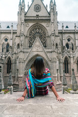 Woman at Church Cathedral. Tourist Girl looking at Quito's cathedral entrance. Gothic architecture with stone facade and arch doorways. Symmetry. Shot in Ecuador. Tourism attraction