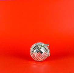 Christmas, new year mood on red background. Mirror disco ball