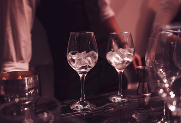 two empty glasses of ice on the bar