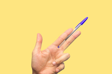 Concept of freedom of speech and information, stop censorship. Hand holding an open pen like a gun. Defend the freedom of Journalism. Yellow background