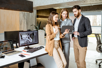 Small group of creative office employees working with digital tablet, standing together in the modern office of architectural firm