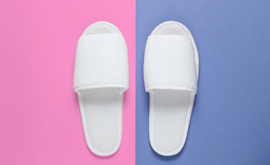 White hotel sleeping slippers on colored background.