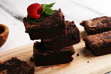chocolate brownie cake dessert with raspberries and spices on a wooden background.