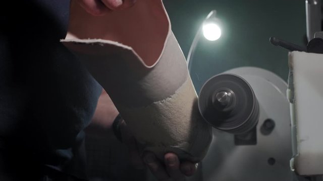 Production of a prosthetic leg. A man creates a part of the leg above the knee. Grinds the plastic part of the leg on a lathe. New body part.