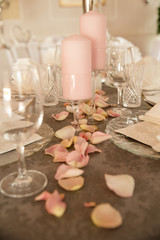 Obraz na płótnie Canvas Hochzeitstisch mit Rosenblättern und rosa Kerzen