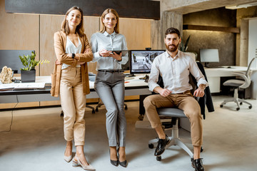 Portrait of a creative and confident team of architects or designers standing together in the modern office studio