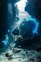 woman diver visiting underwater cave in the Red Sea, egypt, Shaab Claude