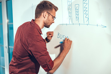 Young man writing down information on the wall